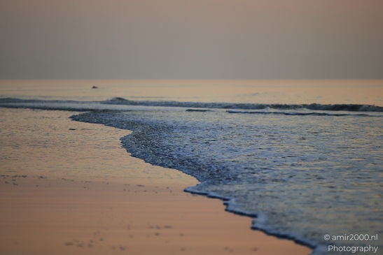 A sunset over the North Sea, with gentle waves lapping against the sandy shore. - image from year 2026 #008