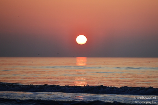 A sunset over the North Sea, with the sun setting behind the horizon and the water reflecting - image from year 2026 #009