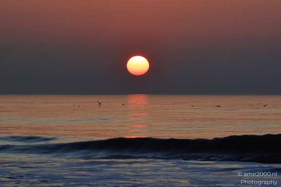A sunset over the North Sea, with the sun setting behind the horizon, casting a warm glow over - image from year 2026 #012