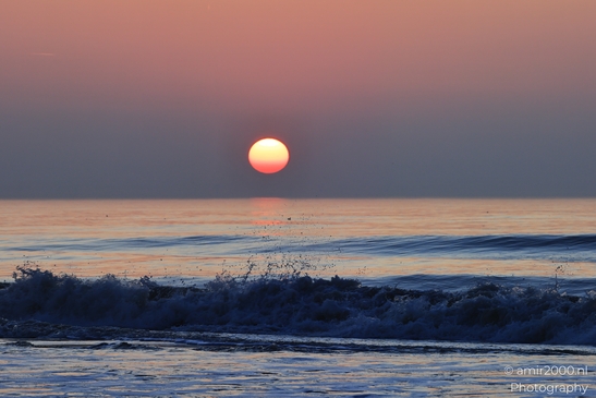A sunset over the North Sea, with the sun setting low in the sky, casting a warm, orange glow - image from year 2026 #013
