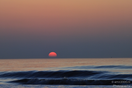A sunset over the North Sea, with the sun setting low on the horizon, casting a warm, orange - image from year 2026 #021