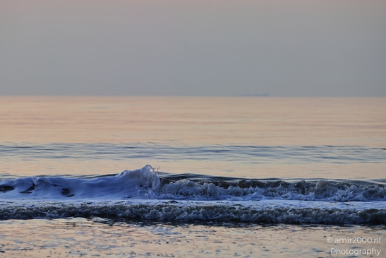 A sunset over the North Sea, with gentle waves lapping against the shore. - image from year 2026 #024