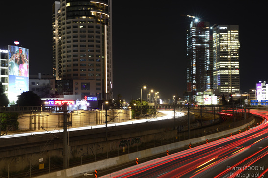 A bustling cityscape at night with illuminated skyscrapers and a busy highway. - image from year 2026 #001