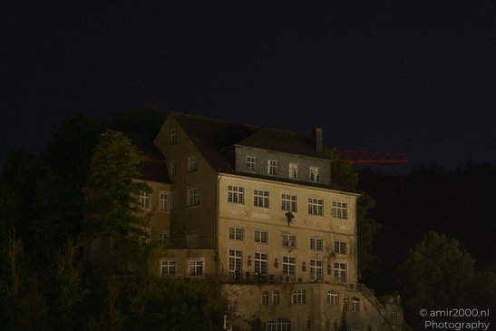 A multi story building with a dark roof, surrounded by trees, at night in Cochem Rhineland - image from year 2026 #014