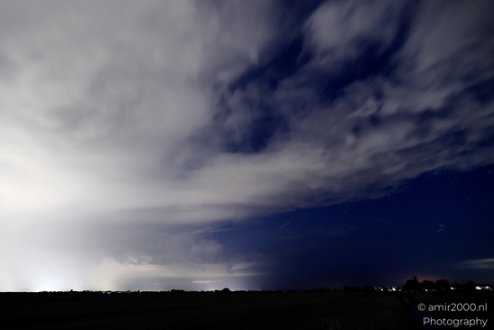 A dramatic night sky over Noord-Holland, Netherlands, filled with dark clouds and illuminated by - image from year 2025 #015